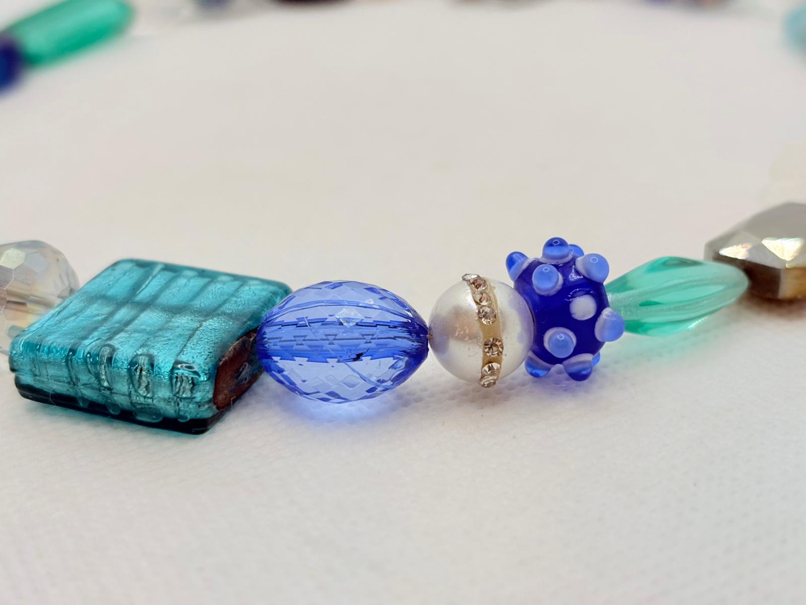 Close-up detail of hand-lampworked glass, pearl and crystal beads